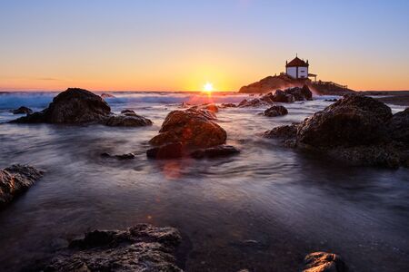 Vila Nova de Gaia, Portugal - June 09, 2019 : On the shoreline the chapel on the cliffs at sunset, Porto district, Portugalの写真素材