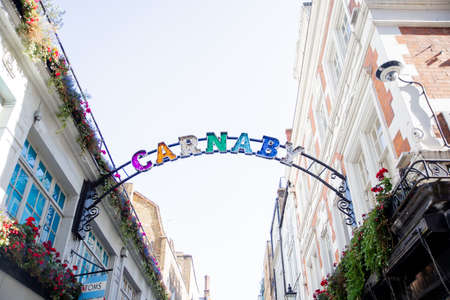 The Carnaby Street Colorful Signboard Hanging Between Two Buildingsのeditorial素材