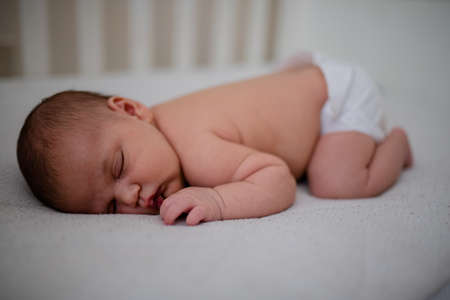 Newborn Baby Girl Sleeping Face Down in Her White Cradle