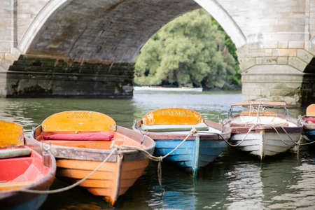 Colorful Boats For Hire Tied Together and Floating on the Riverの写真素材