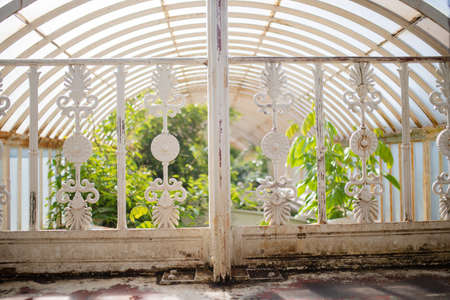 White Railing of a Botanical Garden Plants Under a Curved Ceiling as Background