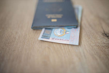 One Kuwaiti Dinar Bill Partially Inside a United States of America Passportの写真素材