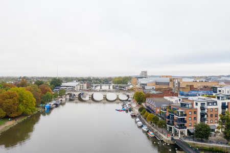 Aerial Landscape View of a River with a Bridge Over it and Under a Cloudy Sky