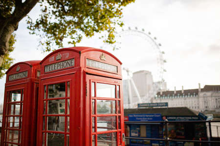 British Telephone Booths Under a Tree and with The London Eye as Backgroundのeditorial素材