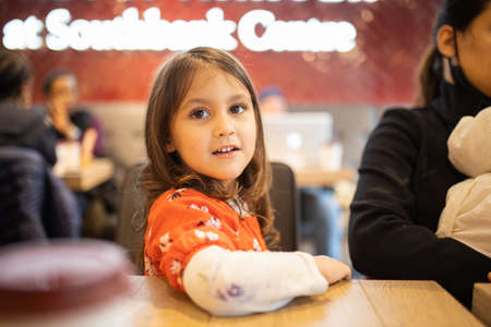 Smiling little girl sitting at the table of a Chinese restaurantの写真素材