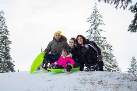 Happy young family smiling on the top of a small snowy hillのeditorial素材