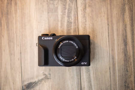 Modern and black pocket camera on a wooden tableのeditorial素材