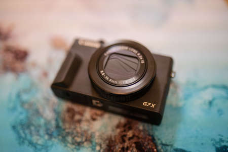 Modern and black pocket camera on a colorful placemat
