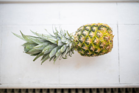 Fresh pineapple on a white tiled kitchen counter