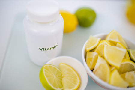 Bottle of vitamins next to bowls of lemon and lime slicesの写真素材