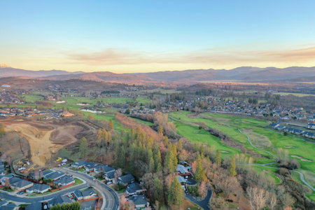 Peaceful town surrounded by trees with mountains as backgroundの写真素材