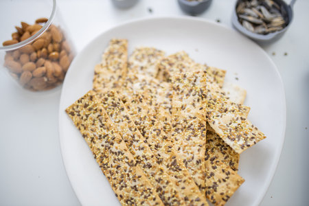 Swedish crispbread on a white plate next to almonds in a cup