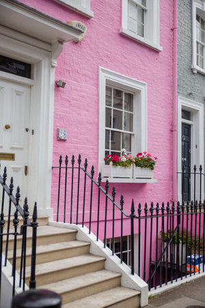 Pink British house with balconies and flowers outside the windowの写真素材