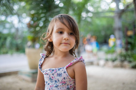 Adorable little girl wearing flowered dress with a blurry backgroundの写真素材