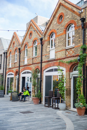 Row of brick buildings in Pavilion Road with people and plants outsideのeditorial素材