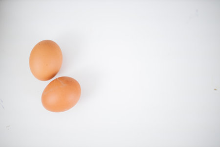 Two eggs isolated on a white table from aboveの写真素材