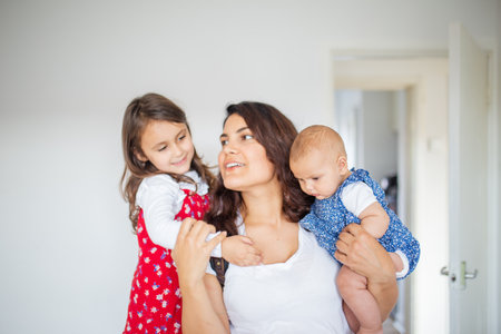 Happy woman hugging her adorable young daughters