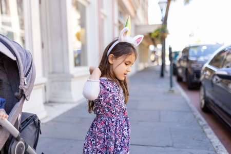 Adorable little girl in the street wearing a unicorn headbandの写真素材