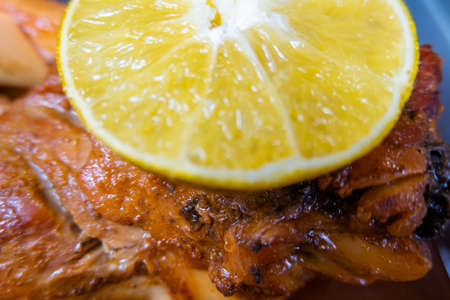 Slice of lemon on top of juicy roasted meatの写真素材