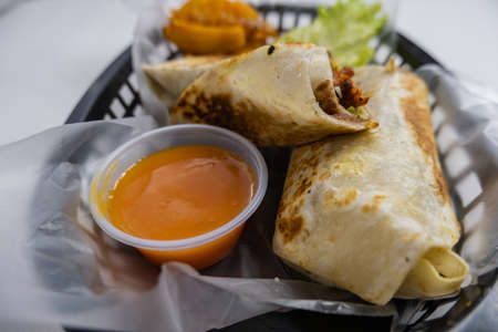 Spicy pork burritos and lettuce in a plastic basketの写真素材