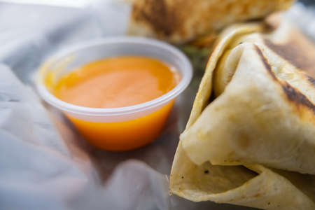 Spicy pork burritos and sauce in a plastic basketの写真素材