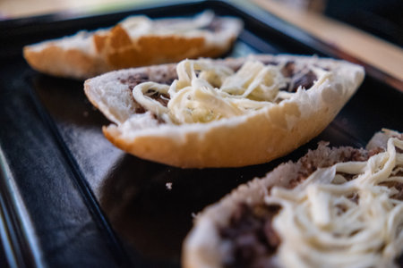Three traditional Mexican molletes on a black trayの写真素材