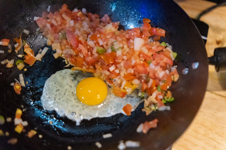 Top view of fried egg and pico de gallo in a frying panの写真素材