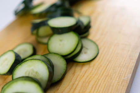 Fresh sliced cucumber on a wooden cutting boardの写真素材