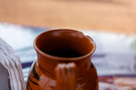 Handmade clay cup and paper napkins with blurry backgroundの写真素材