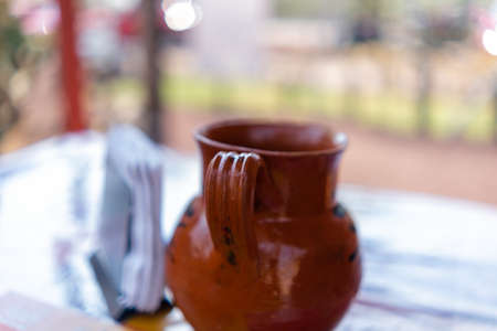 Handmade clay cup and paper napkins with blurry backgroundの写真素材
