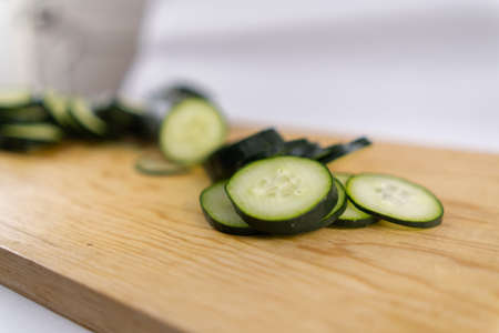 Fresh sliced cucumber on a wooden cutting boardの写真素材