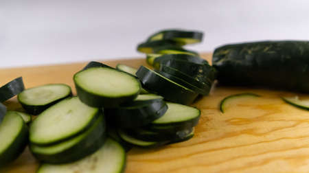 Fresh sliced cucumber on a wooden cutting boardの写真素材