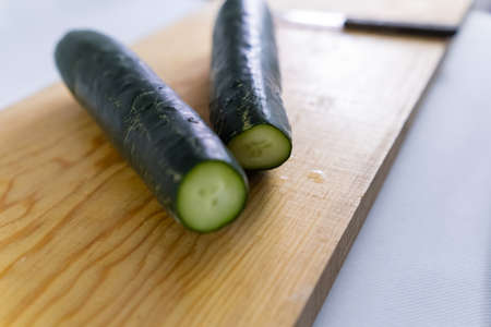 Fresh cucumbers isolated on a wooden cutting boardの写真素材
