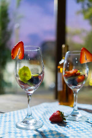 Wine glasses with strawberry and kiwi slices on a checkered tableclothの写真素材