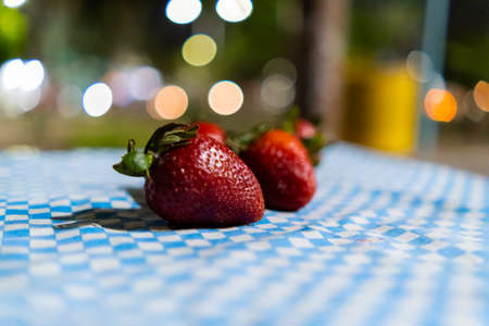 Fresh strawberries on a checkered tablecloth with blurry backgroundの写真素材