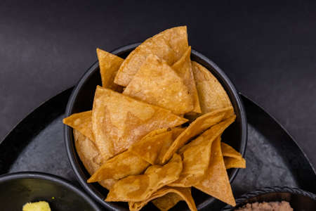 Bowl of tortilla chips on a traditional Mexican comal