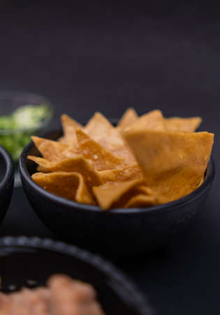 Bowls of tortilla chips and refried beans with black backgroundの写真素材
