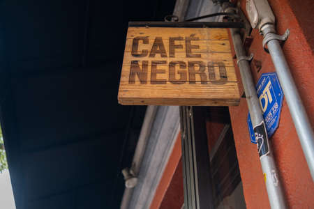 Wooden sign with Spanish text hanging from red wallのeditorial素材