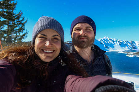 Happy woman and man with beautiful snowy mountain range as backgroundの写真素材