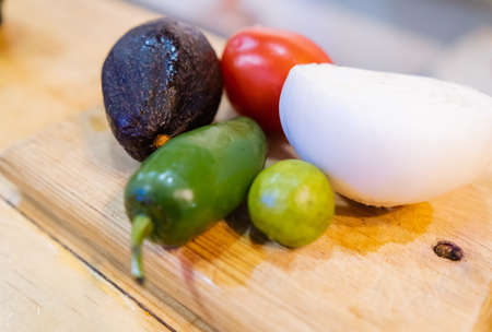Colorful vegetables on wooden cutting board with blurry background