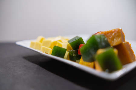 Plate of fresh diced cheese and fruit paste slices