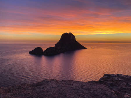 Es Vedra with a sunset over the seaの写真素材