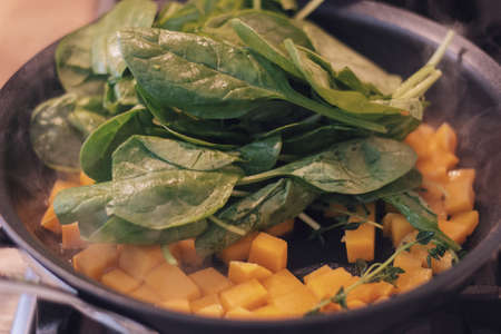 Spinach in a wok with other vegetables