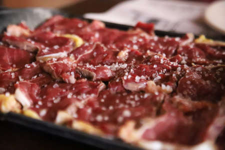 Fresh meat sprinkled with large pieces of saltの写真素材