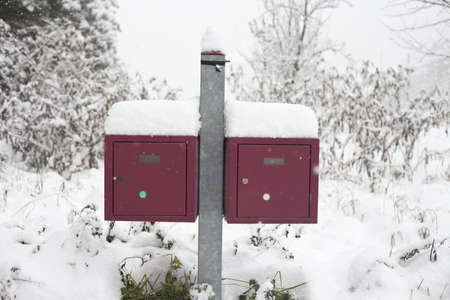 Two red boxes inthe snow on a winter dayの写真素材