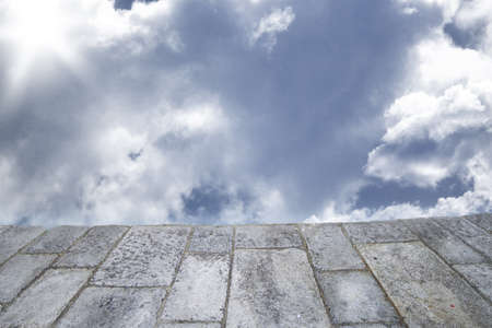 Background with stone pavement and cloudy skyの写真素材