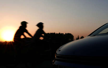 The shadow of car shape and cycling couple at beautiful sunset