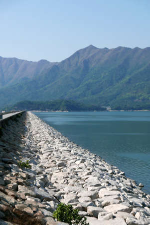 dam pond, mountains and blue sky during the daytimeの写真素材