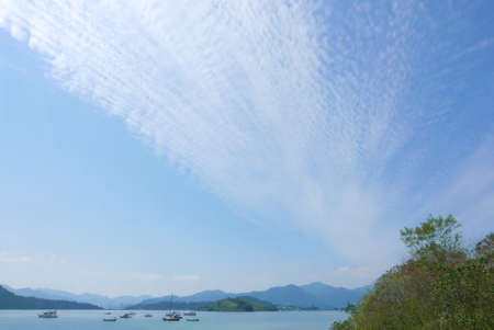 Fishing and motor boats with blue sky and cloudsの写真素材