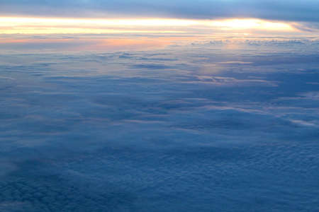 white fluffy clouds and the sun at sunset